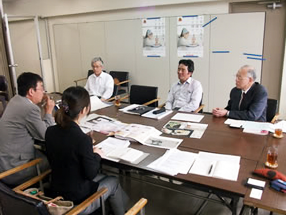 株式会社ハッピージャパンの方と対面で話を伺う当店スタッフ